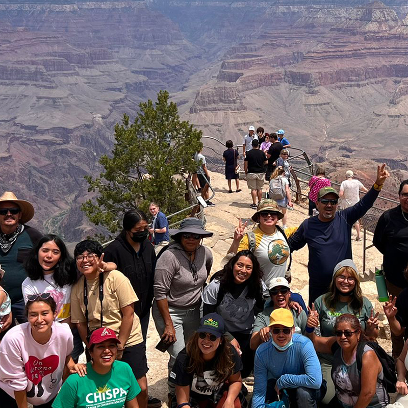 Group of people posing in front of the Grand Canyon.