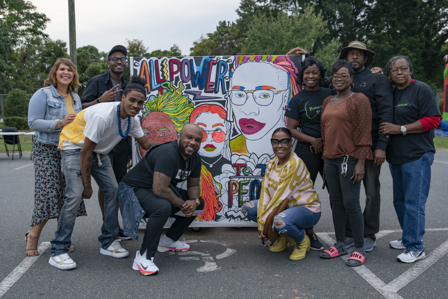 A group of North Carolina community organizers posing with a mural celebrating National Civic Engagement Week