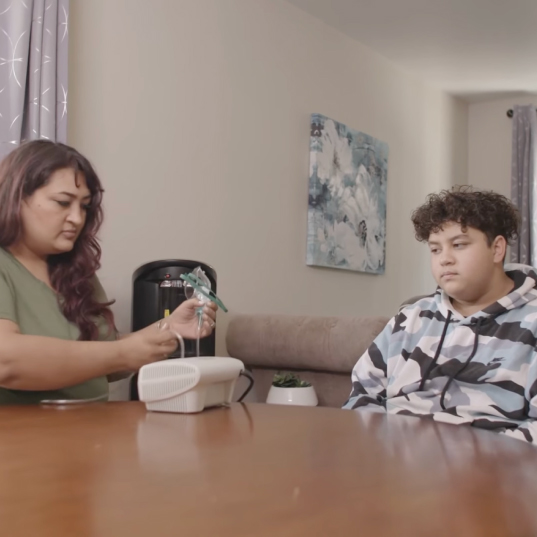 Ana Loaiza-Campean sets up the breathing machine for her son