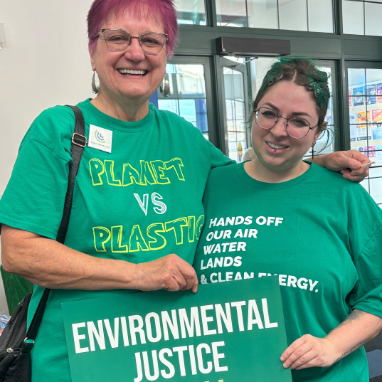 Climate Action volunteers pose with signs calling for environmental justice