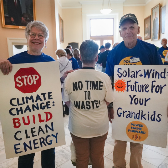 Activists in Maine hold signs calling for clean energy
