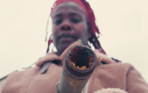 Shy McElroy holds a lead pipe and shows the build up inside